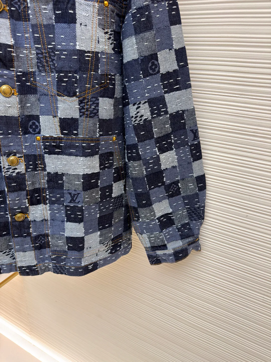 LOUIS VUITTON ●Description: Using denim fabric to create a standard version, the Damier jacquard texture pattern is presented through exquisite splicing technology, showing Nigo's deep understanding of Japanese traditional craftsmanship. The design cleverly combines workwear elements with modern aesthetics. The curved collar line is smooth and elegant, perfectly balanced with the overall silhouette. The details are embellished with shiny domed metal buttons and rivets, adding sophistication to the overall look. Adjustable straps at the back waist ensure comfort. The overall wiring is straight and delicate, the fabric is comfortable and soft, and the color is consistent without color difference. It can be matched with the same style to create a fashionable look and control various occasions. Customized accessories, complete with three standards, same style for men and women!